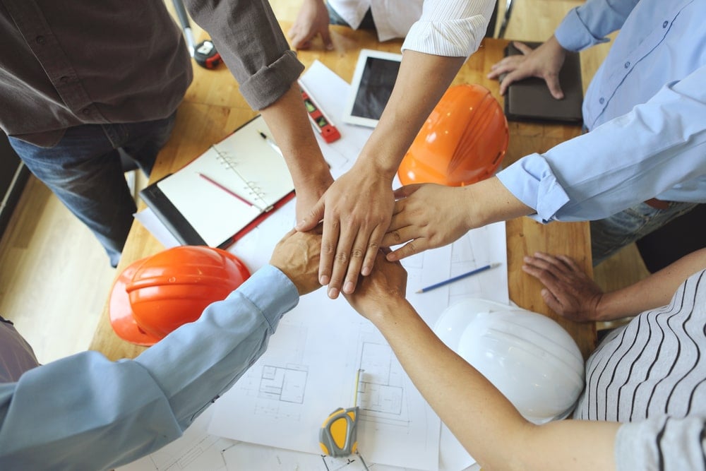 Group of employees putting their hand in a circle