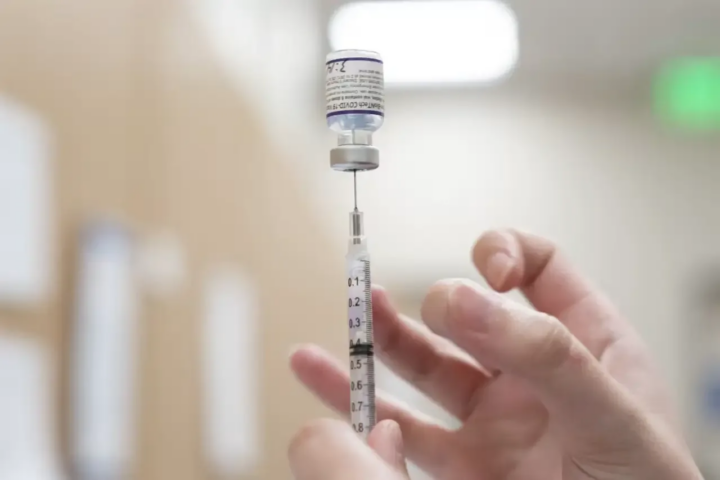 Doctor tapping medication to get air bubbles