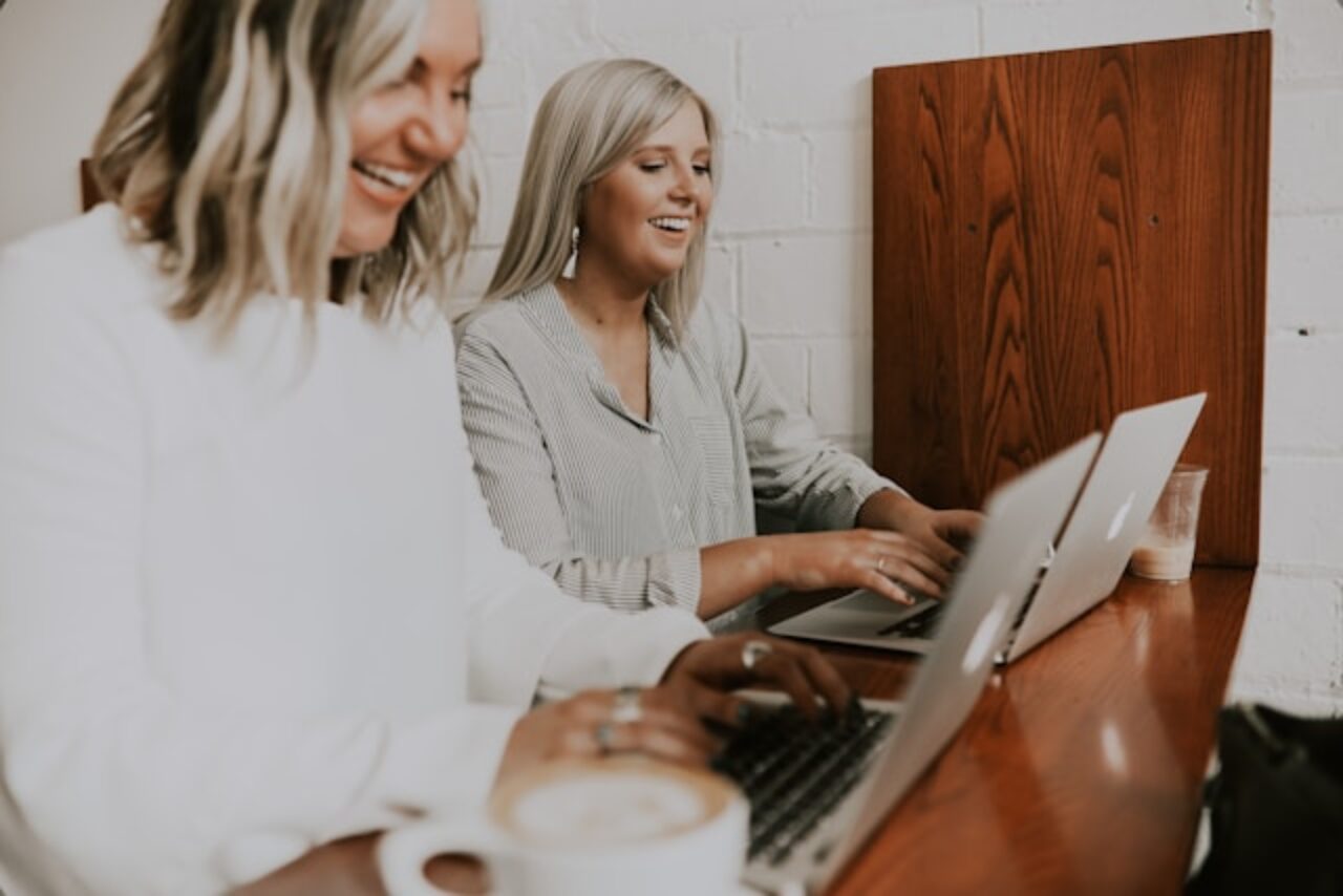 Two female employees working on laptops