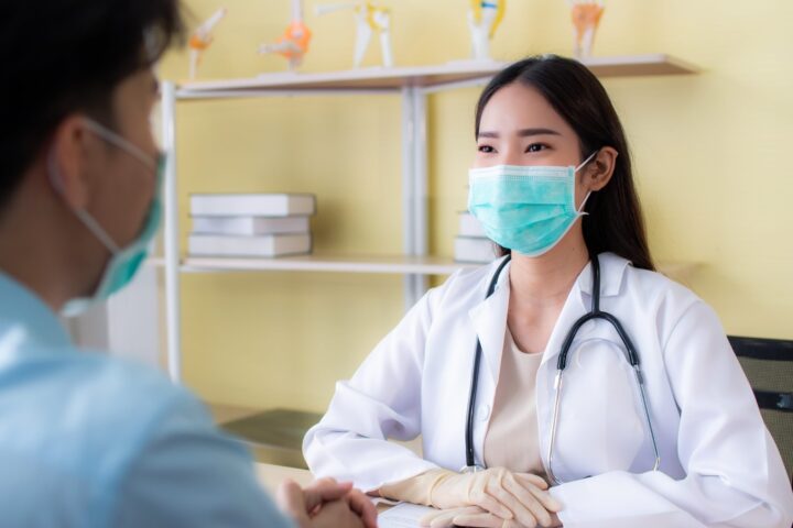 female doctor with mask on looking at patient