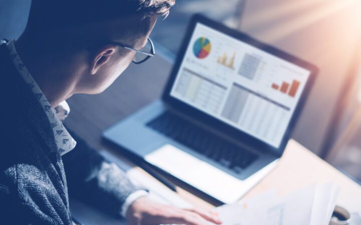 man looking at charts and graphs on computer screen