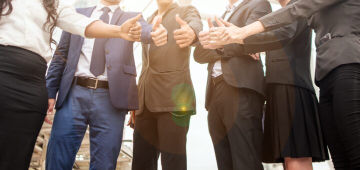 men in business suits giving a thumbs up